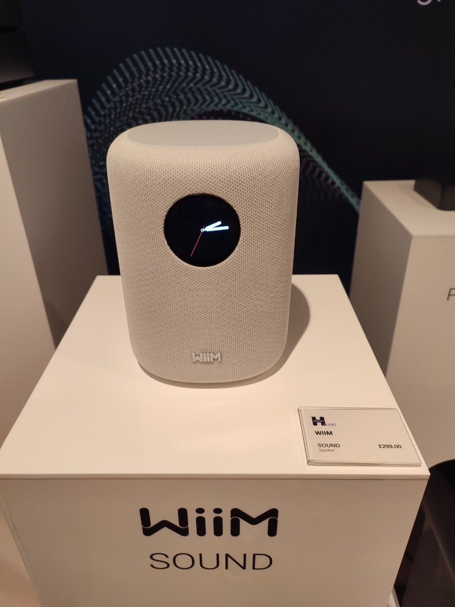 WiiM Sound smart speaker with circular touch display shown at Ascot event